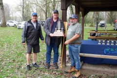 Three men standing with a trophy