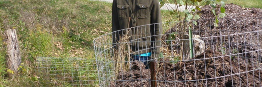 Brandon Jordan stands beside one of the Eastern Foxsnake artificial nesting boxes used to enhance the habitat for this endangered species