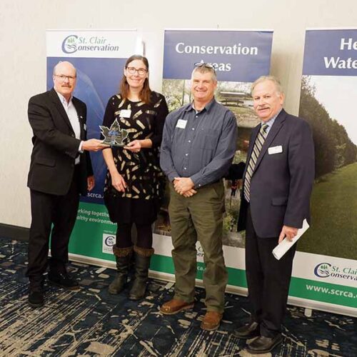 Pat Brown, Vivian Crump, Chris Crump, and Mike Stark stand in front of St. Clair Region Conservation Authority banners.