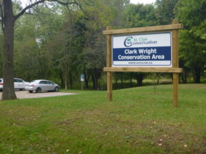 Clark Wright Conservation Area sign with trees and parking lot in background