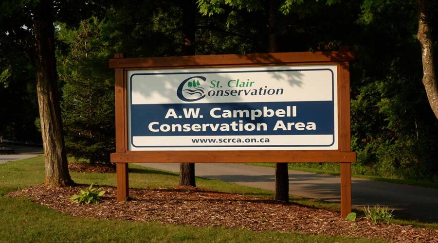 A.W. Campbell Conservation Area entrance sign with trees and grass.